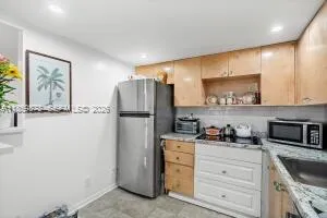 a kitchen with stainless steel appliances granite countertop a refrigerator and a stove top oven