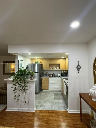 a kitchen with stainless steel appliances kitchen island granite countertop a stove refrigerator and cabinets