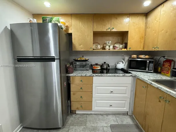 a kitchen with appliances a refrigerator and cabinets