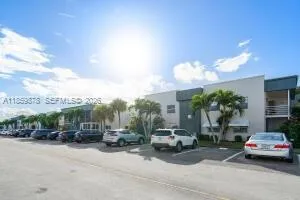 a view of a cars park in front of a building