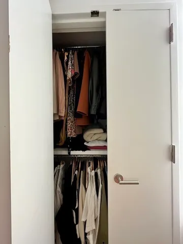 a view of walk in closet with clothes and shoes