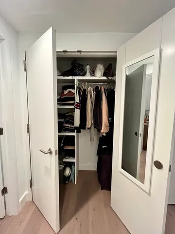 a view of walk in closet with clothes and shoes
