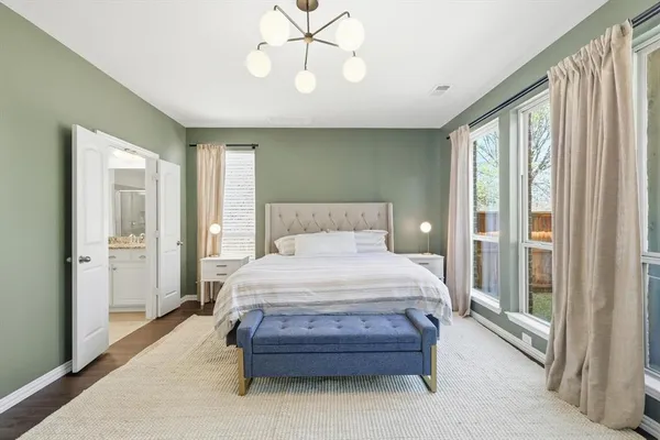 a bedroom with a large bed and a chandelier