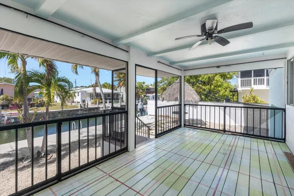 an empty room with windows closet and chandelier fan