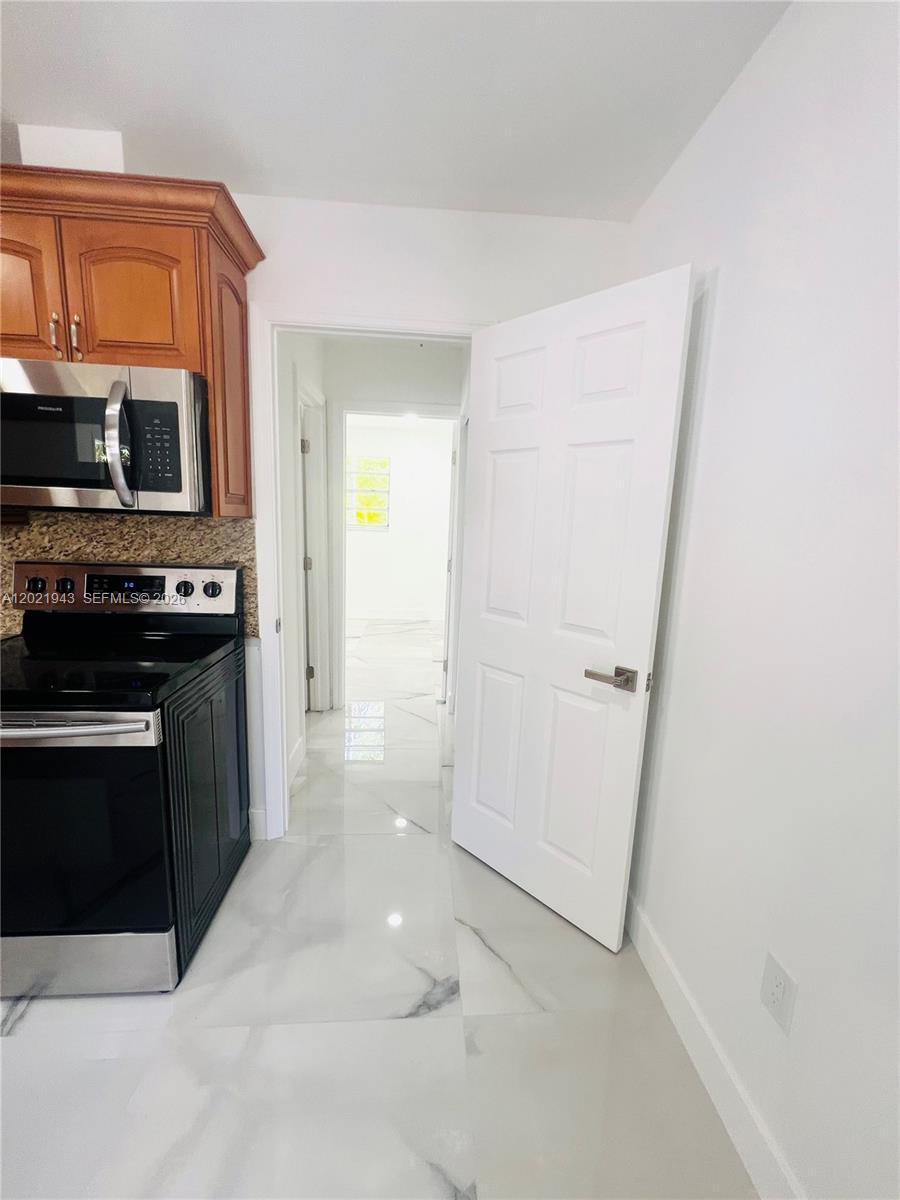 15530 Southwest 295th Terrace Homestead, FL 33033 - Photo 7 of 14 a kitchen with a stove and a microwave