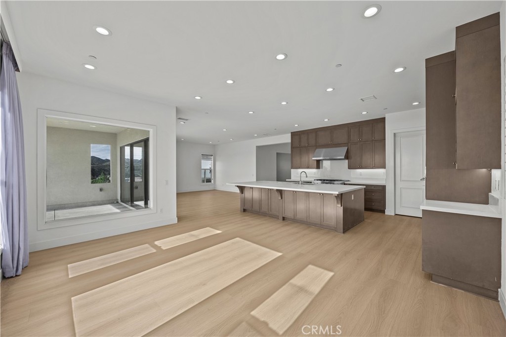 20638 Deer Grass Court Porter Ranch, CA 91326 - Photo 20 of 50 a large white kitchen with a large counter top a sink stainless steel appliances and cabinets