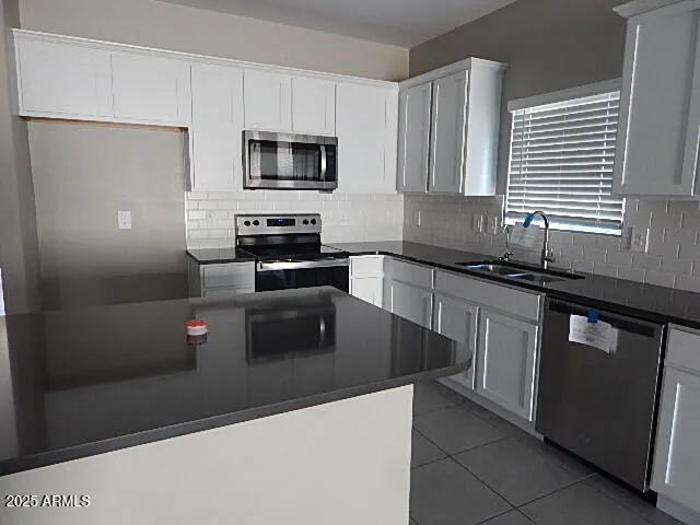 a kitchen with granite countertop a refrigerator and a sink