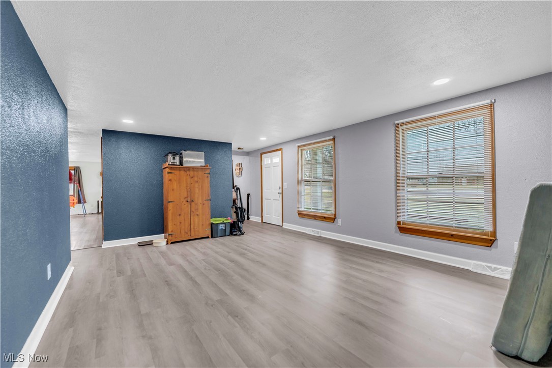 14808 Darrow Road Vermilion, OH 44089 - Photo 5 of 45 Unfurnished living room featuring a textured ceiling and light wood-type flooring