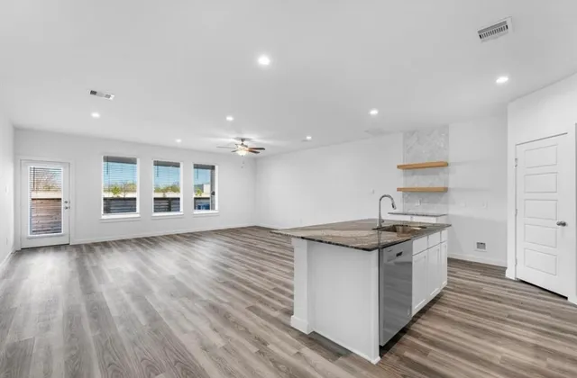a kitchen with stainless steel appliances granite countertop a sink stove and wooden floor