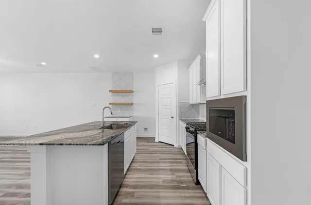 a kitchen with stainless steel appliances granite countertop a stove and a refrigerator
