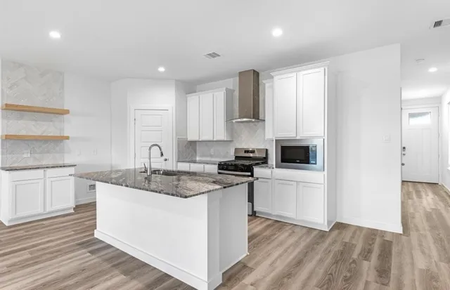 a kitchen with a sink stove cabinets and refrigerator