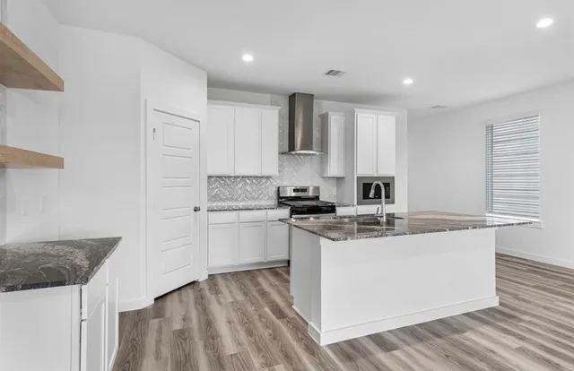 a kitchen with stainless steel appliances granite countertop a sink stove and refrigerator