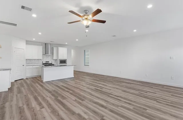 a view of kitchen with granite countertop cabinets and refrigerator