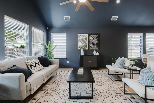 a living room with furniture ceiling fan and a window