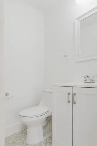 a white toilet sitting next to a bathroom sink
