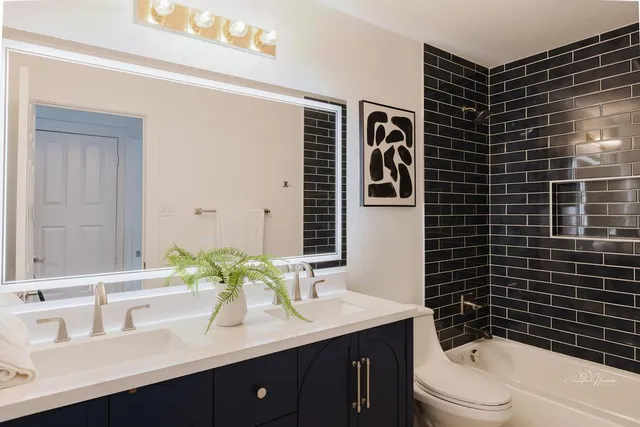 a bathroom with a granite countertop toilet sink a mirror a shower and vanity