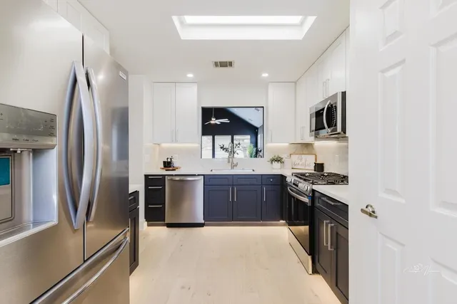 a kitchen with stainless steel appliances granite countertop a refrigerator stove and sink