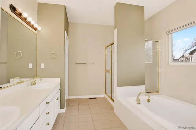 a spacious bathroom with a tub sink and mirror