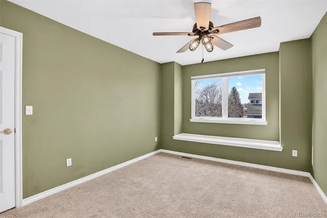 a view of a room with a window and a ceiling fan