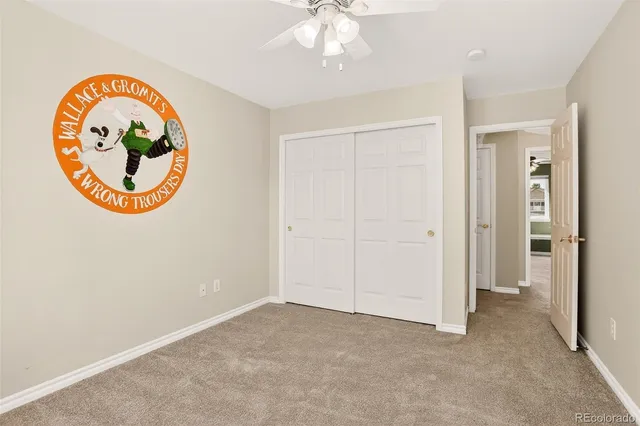 an empty room with a large window and a chandelier fan