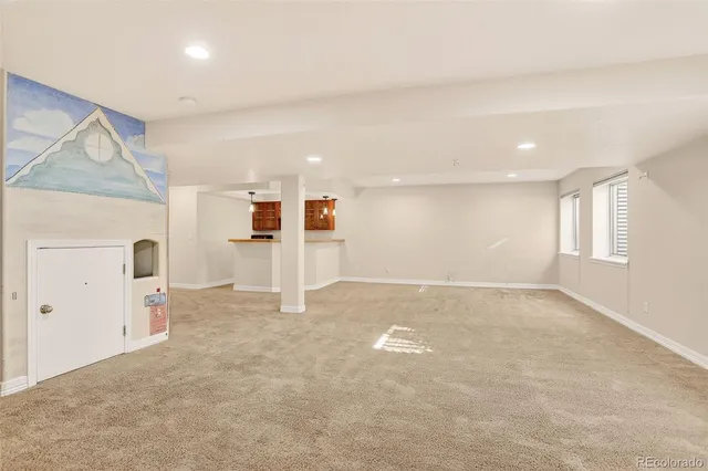 a view of a kitchen with a refrigerator and white cabinets