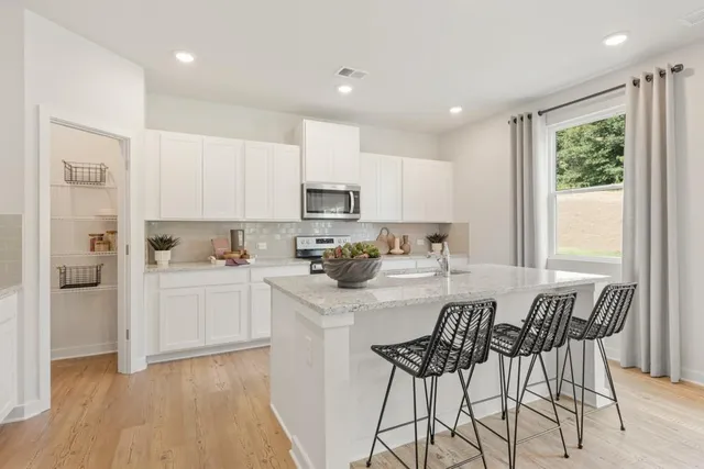 a kitchen with a dining table chairs refrigerator and cabinets