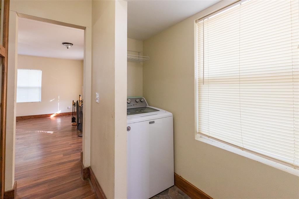 640 Ground Street Moran, TX 76464 - Photo 13 of 35 Dedicated laundry area featuring a top-load washer, overhead wire shelving, and a window with blinds