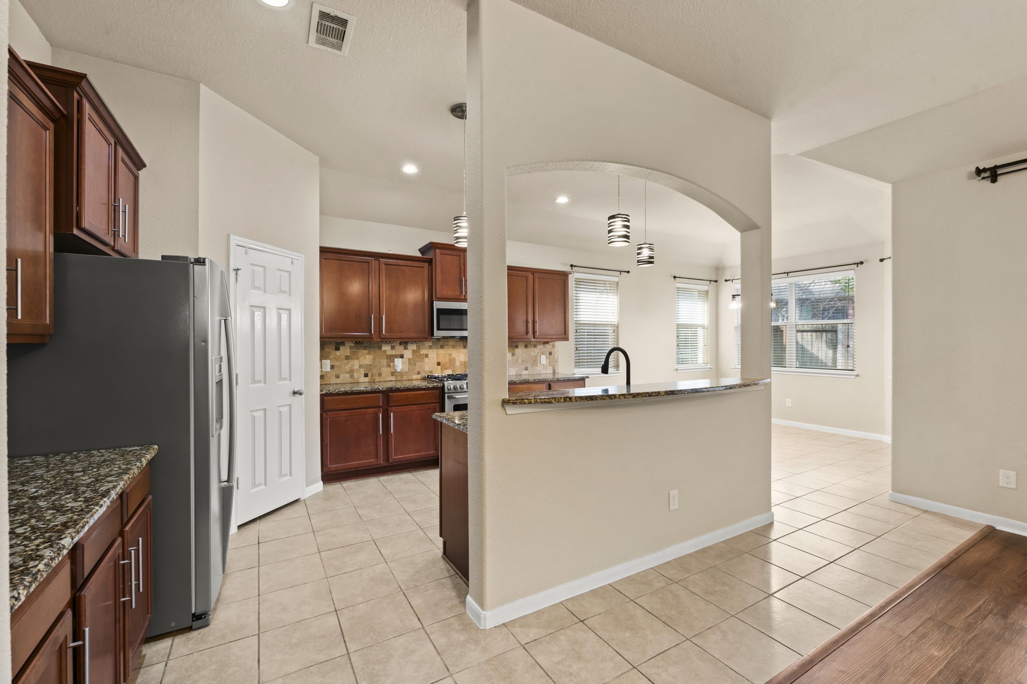 1906 Pagemill Lane Conroe, TX 77304 - Photo 12 of 41 a kitchen with stainless steel appliances kitchen island granite countertop a refrigerator and a stove top oven