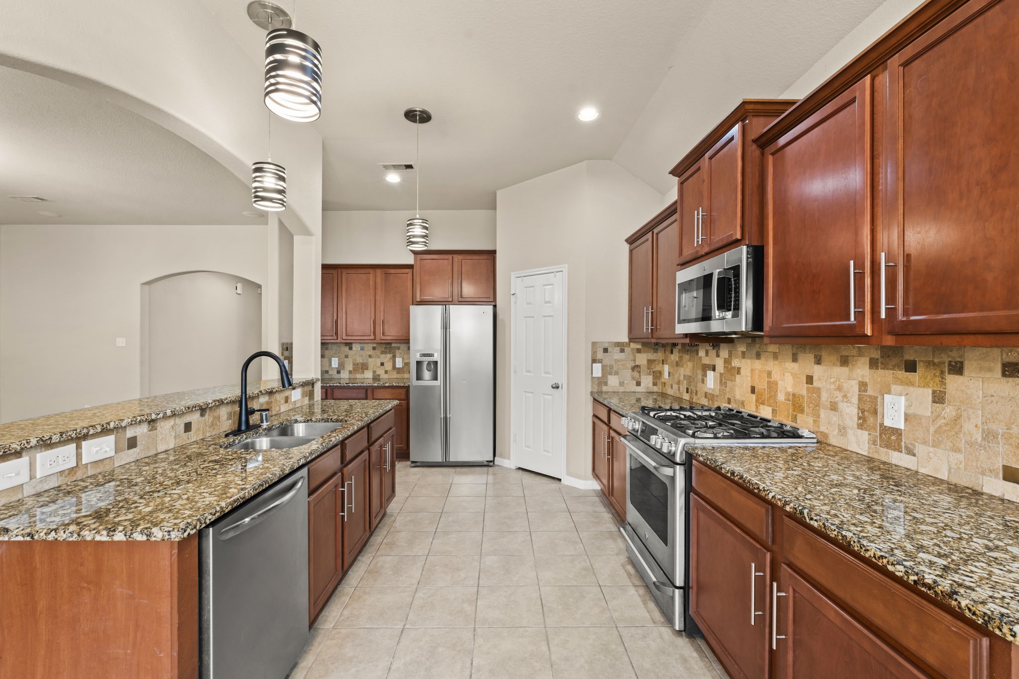 1906 Pagemill Lane Conroe, TX 77304 - Photo 13 of 41 a kitchen with stainless steel appliances granite countertop a sink stove and refrigerator