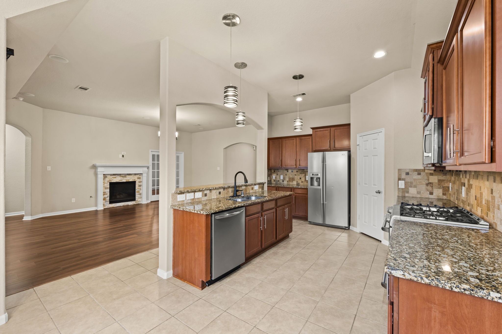1906 Pagemill Lane Conroe, TX 77304 - Photo 14 of 41 a large kitchen with stainless steel appliances granite countertop a stove and a refrigerator
