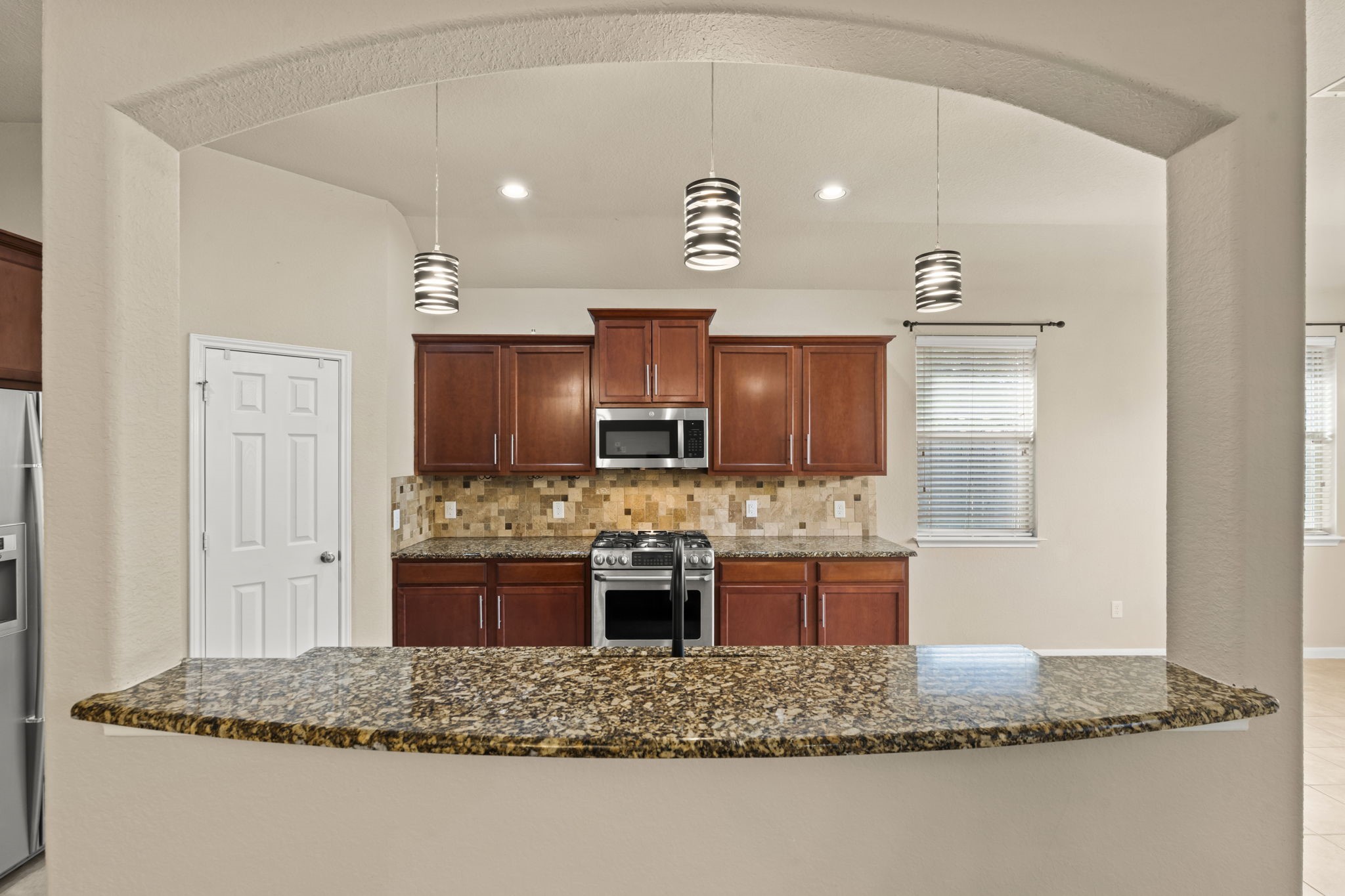 1906 Pagemill Lane Conroe, TX 77304 - Photo 16 of 41 a kitchen with kitchen island granite countertop a sink and a stove