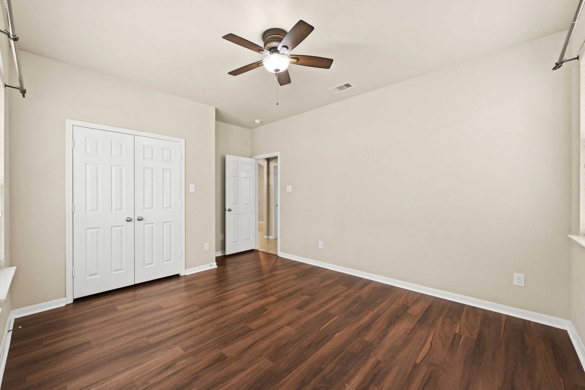 1906 Pagemill Lane Conroe, TX 77304 - Photo 31 of 41 an empty room with wooden floor ceiling fan and window