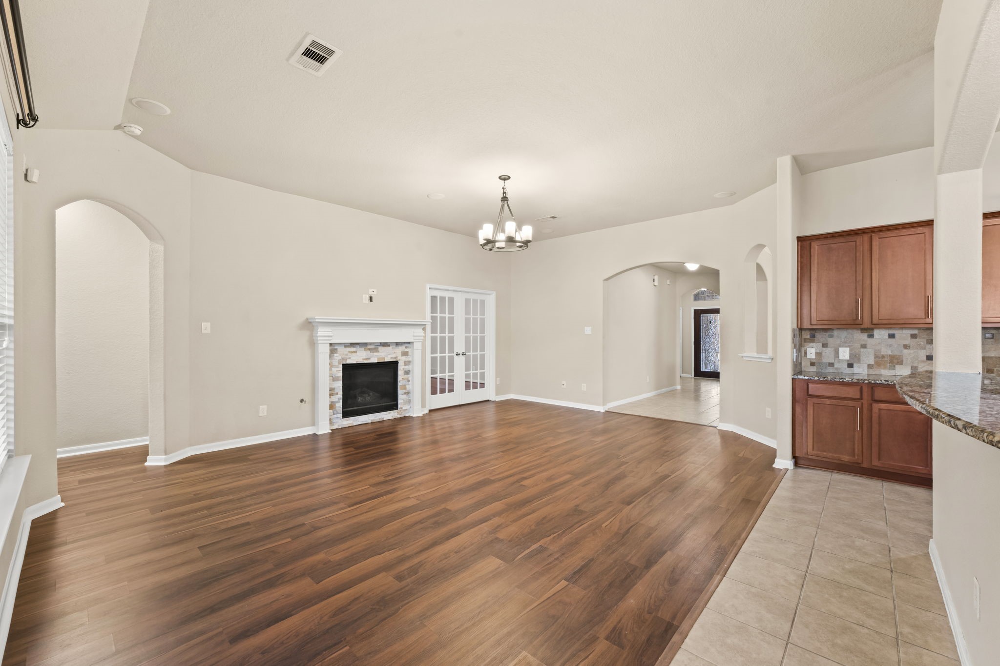 1906 Pagemill Lane Conroe, TX 77304 - Photo 9 of 41 a large kitchen with granite countertop a stove a sink dishwasher and a fireplace with wooden floor