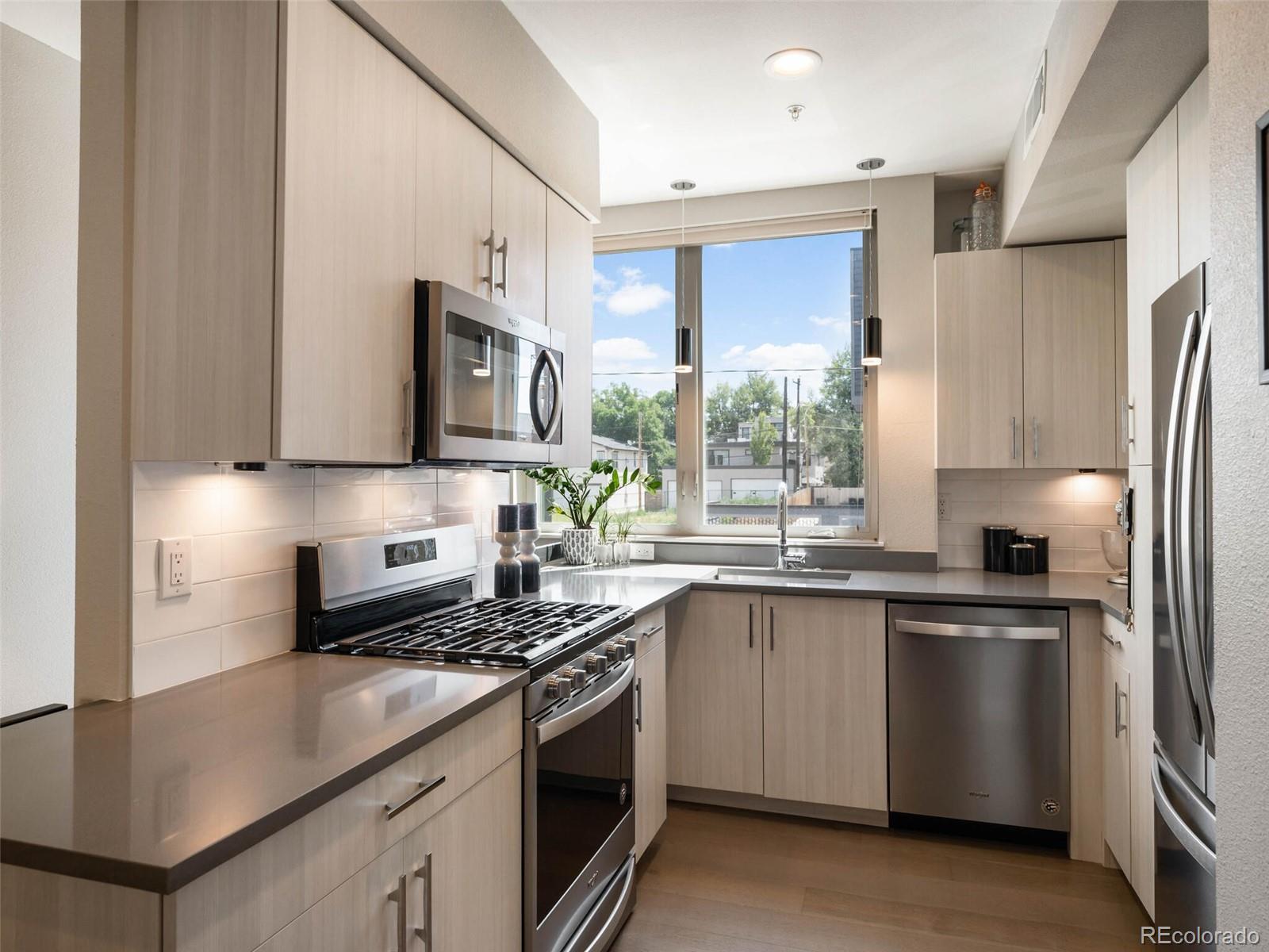 a kitchen with stainless steel appliances a sink cabinets and a window