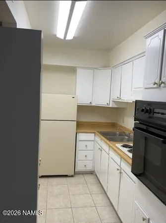 a kitchen with a refrigerator sink and cabinets