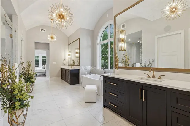 a spacious bathroom with a double vanity sink a large mirror and a shower