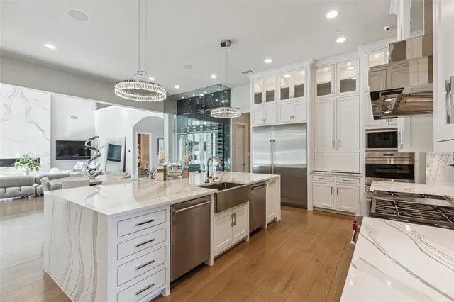 a large kitchen with stainless steel appliances lots of counter space and wooden floor