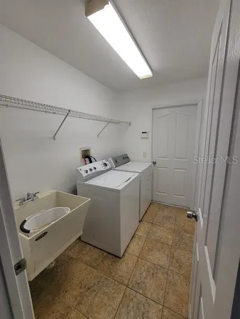 a utility room with a sink a washer and dryer