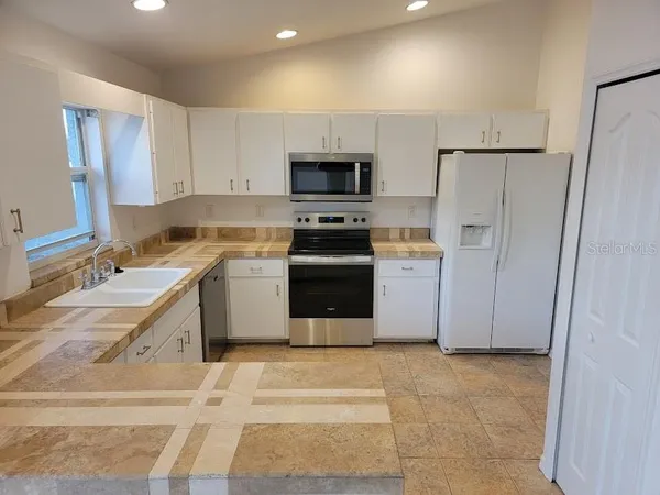 a kitchen with a sink a stove and refrigerator