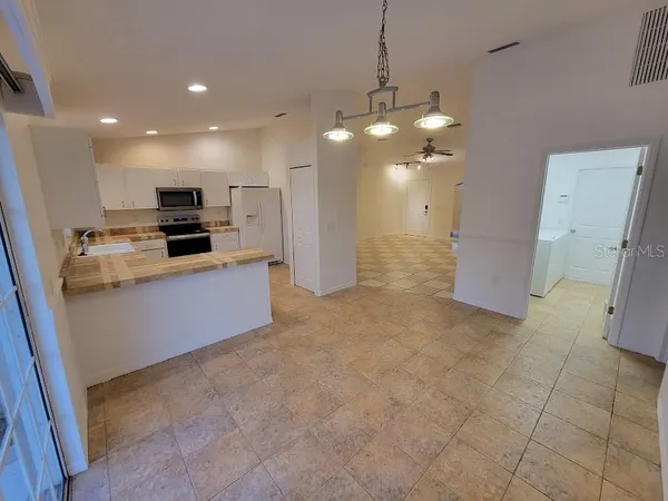 a view of a kitchen with a sink and refrigerator