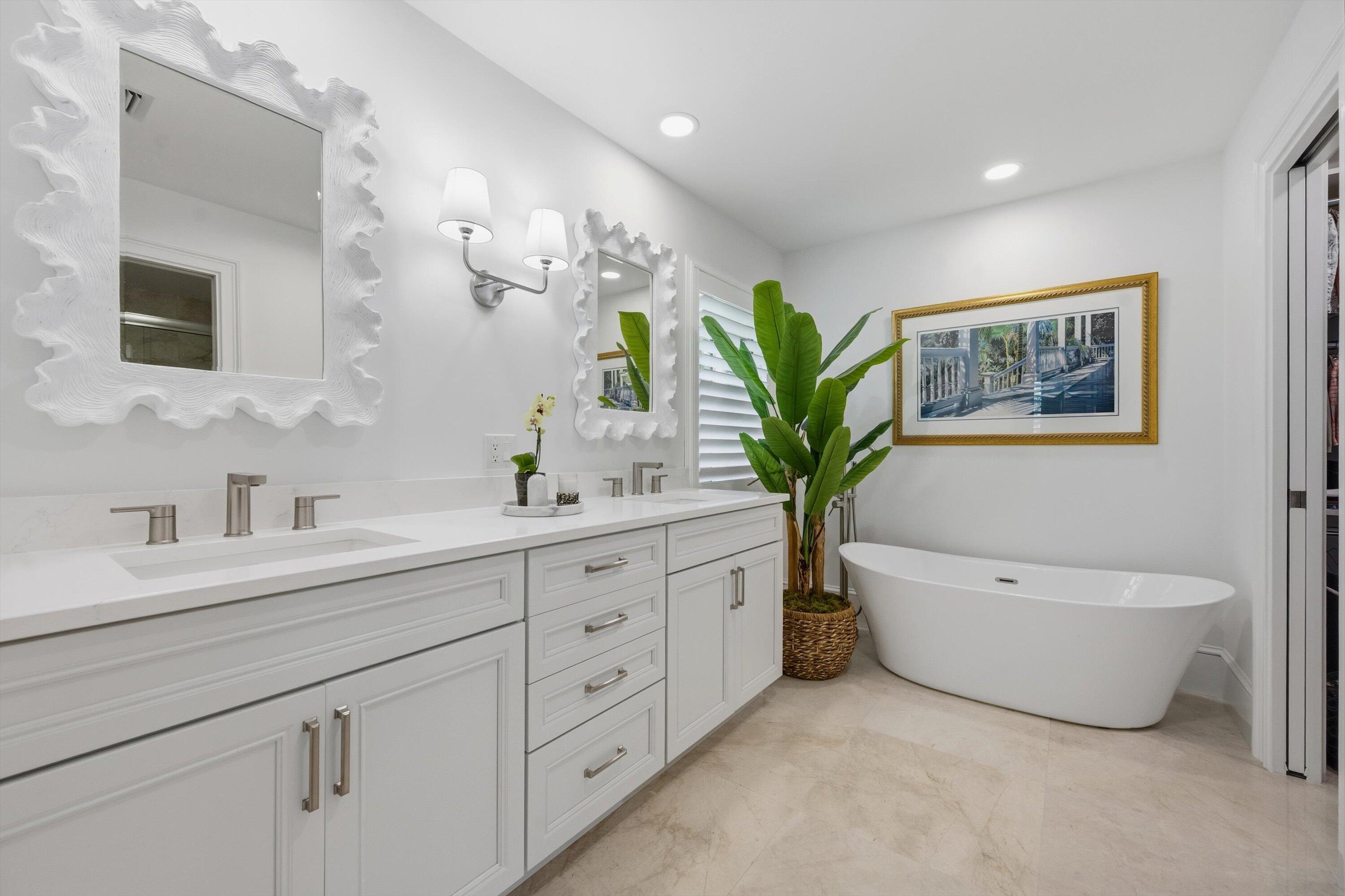 9039 Southeast Hawksbill Way Hobe Sound, FL 33455 - Photo 23 of 45 a spacious bathroom with a double vanity sink a mirror and a bathtub