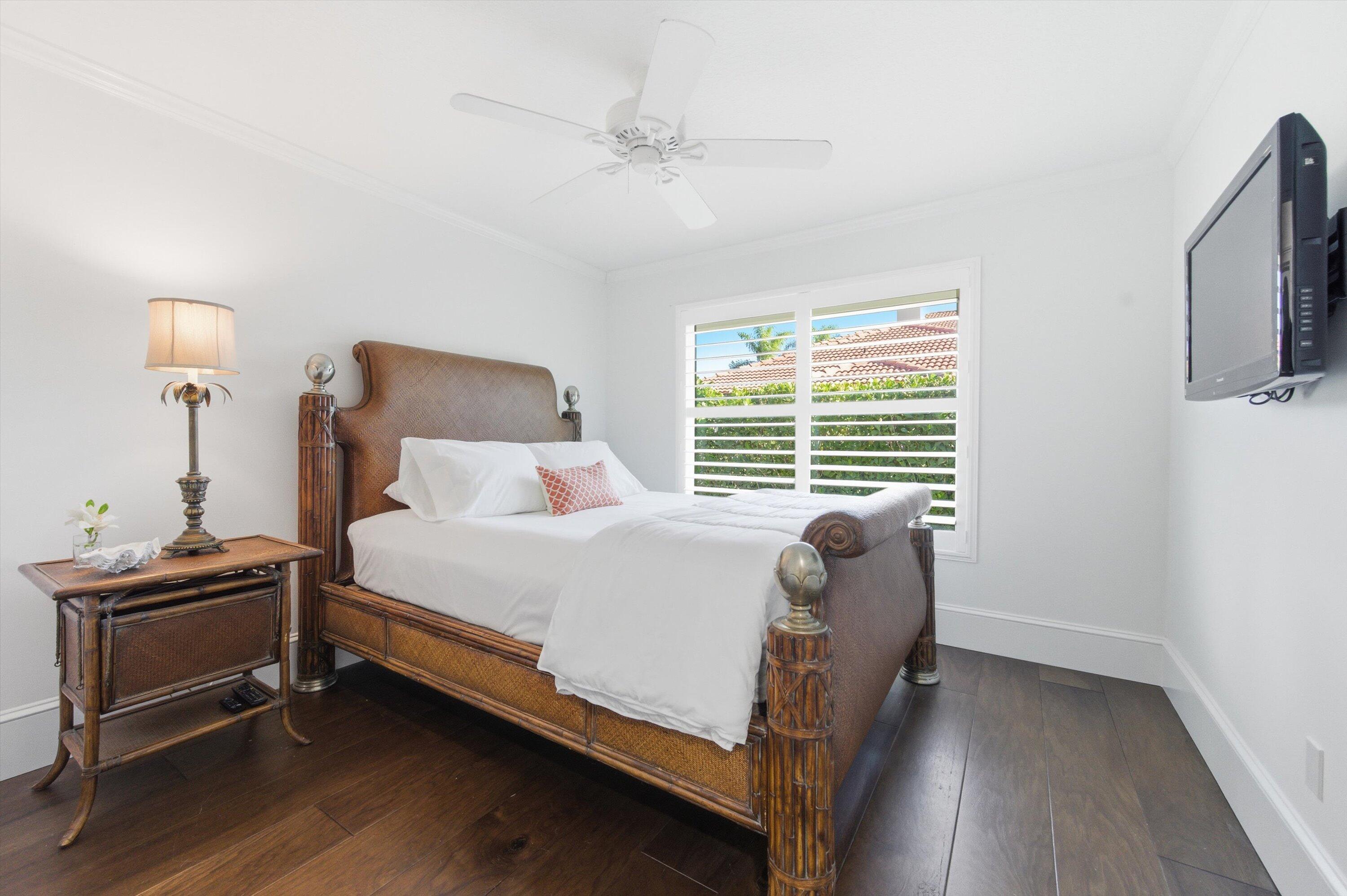 9039 Southeast Hawksbill Way Hobe Sound, FL 33455 - Photo 25 of 45 a bed sitting in a bedroom next to a window