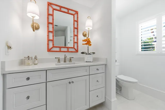 a bathroom with a toilet a sink a and mirror