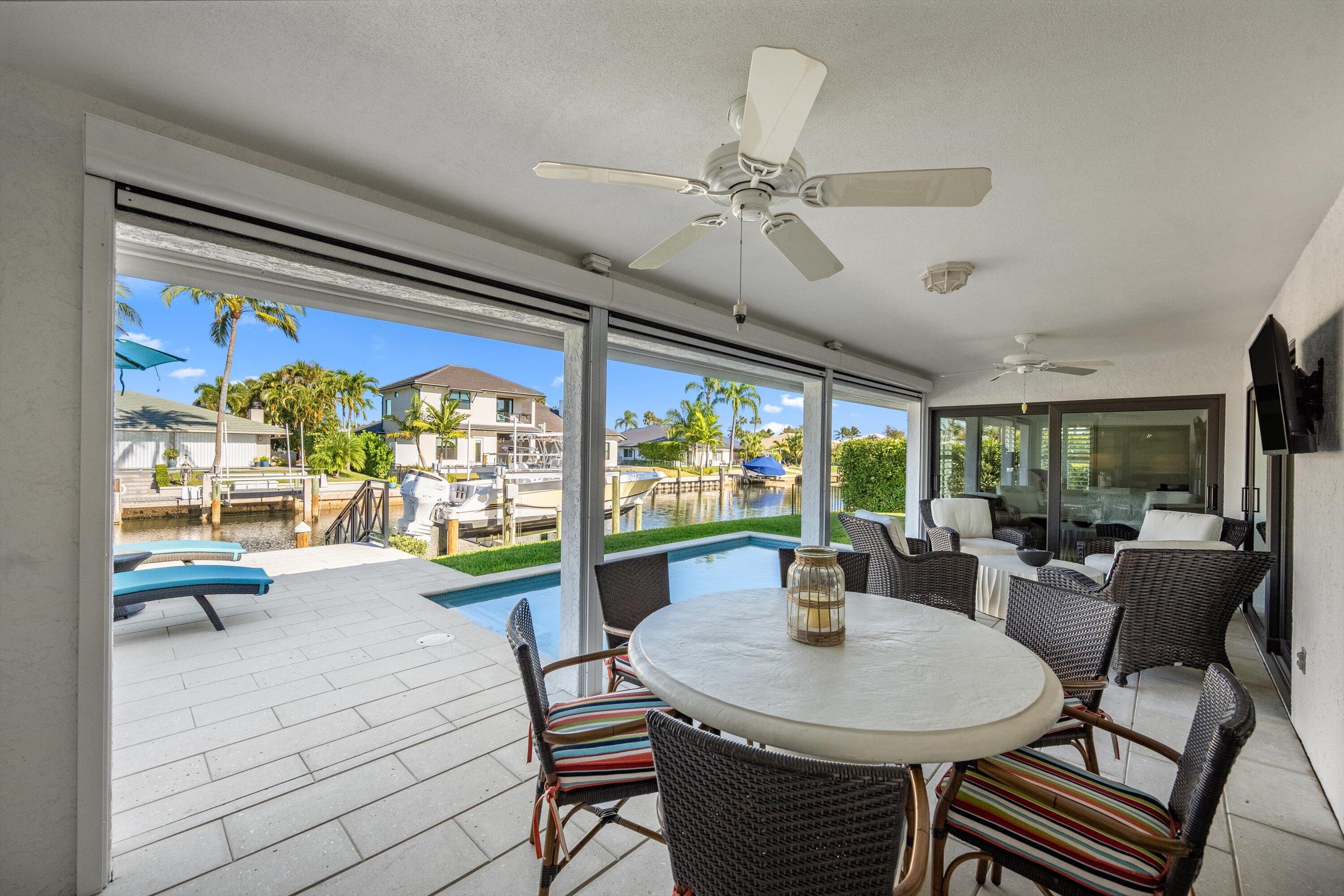 9039 Southeast Hawksbill Way Hobe Sound, FL 33455 - Photo 32 of 45 a view of a dining room with furniture large windows and wooden floor