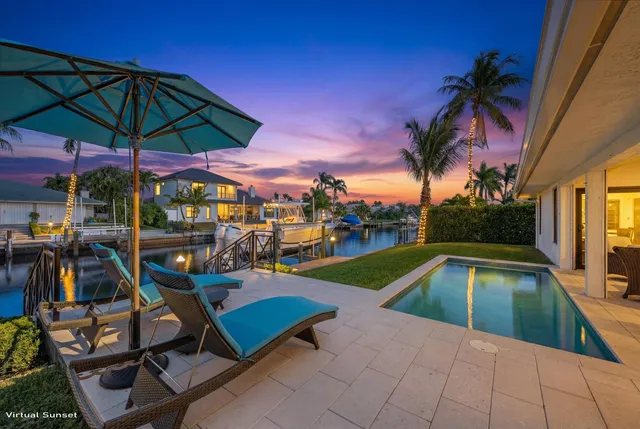 a view of swimming pool with chairs and umbrella