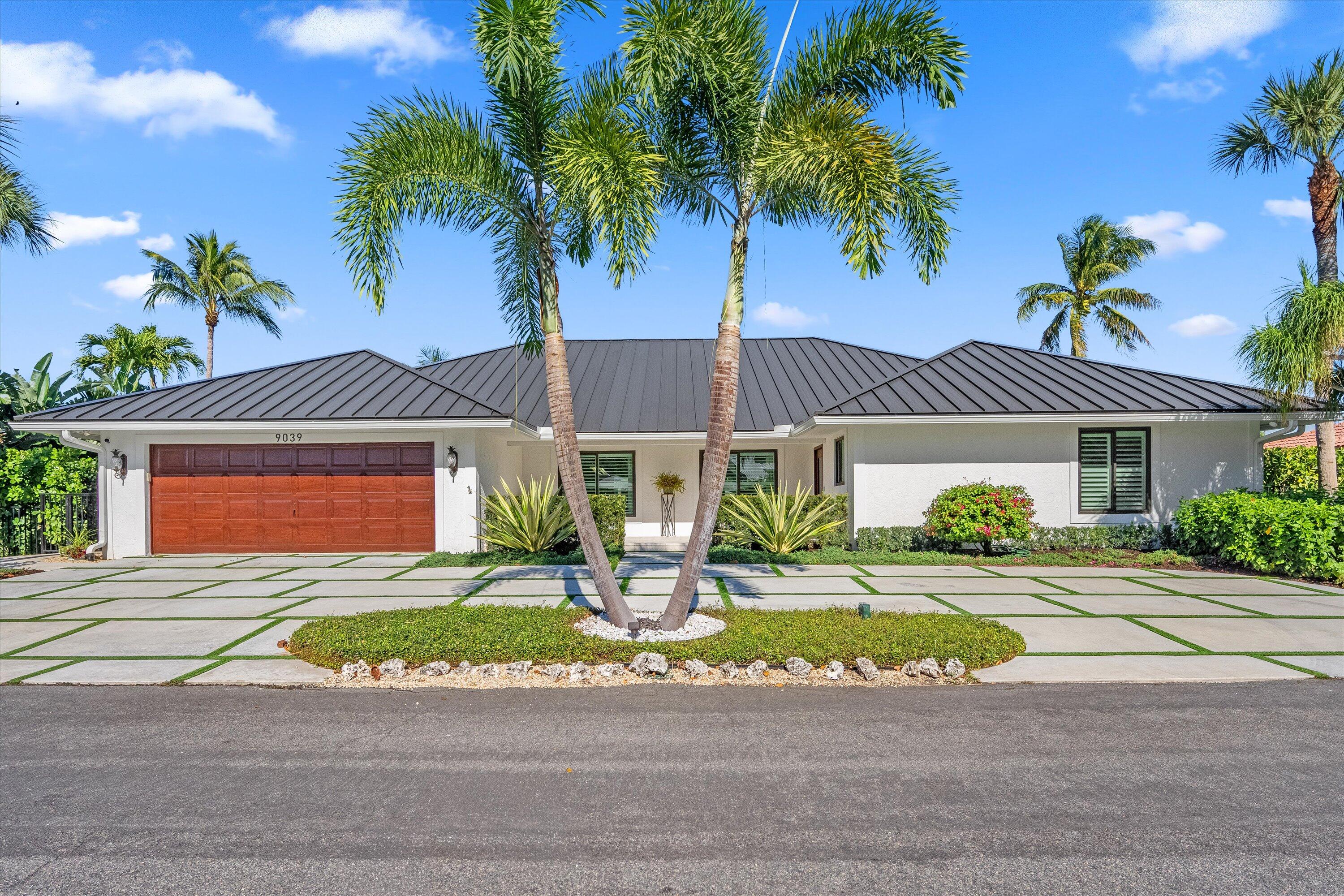 9039 Southeast Hawksbill Way Hobe Sound, FL 33455 - Photo 6 of 45 a front view of a house with a yard and potted plants