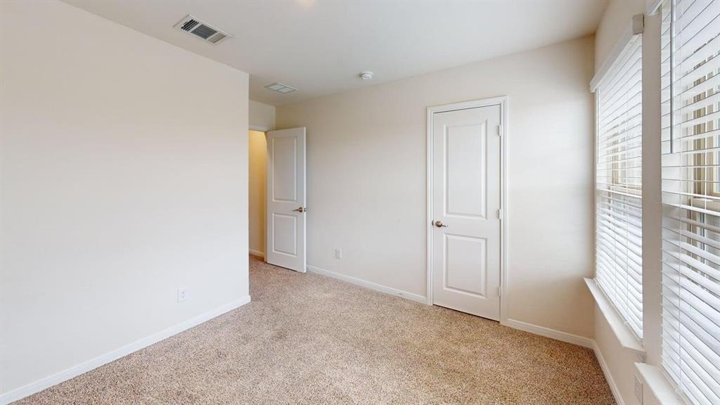 1306 Colonial Bluff Lane Princeton, TX 75407 - Photo 14 of 27 Light-colored walls with trim work, neutral-toned carpet, white paneled doors, and a window with horizontal blinds