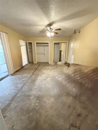 an empty room with windows and cabinet