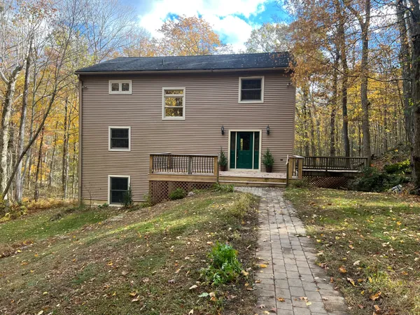 a view of backyard of house with wooden fence