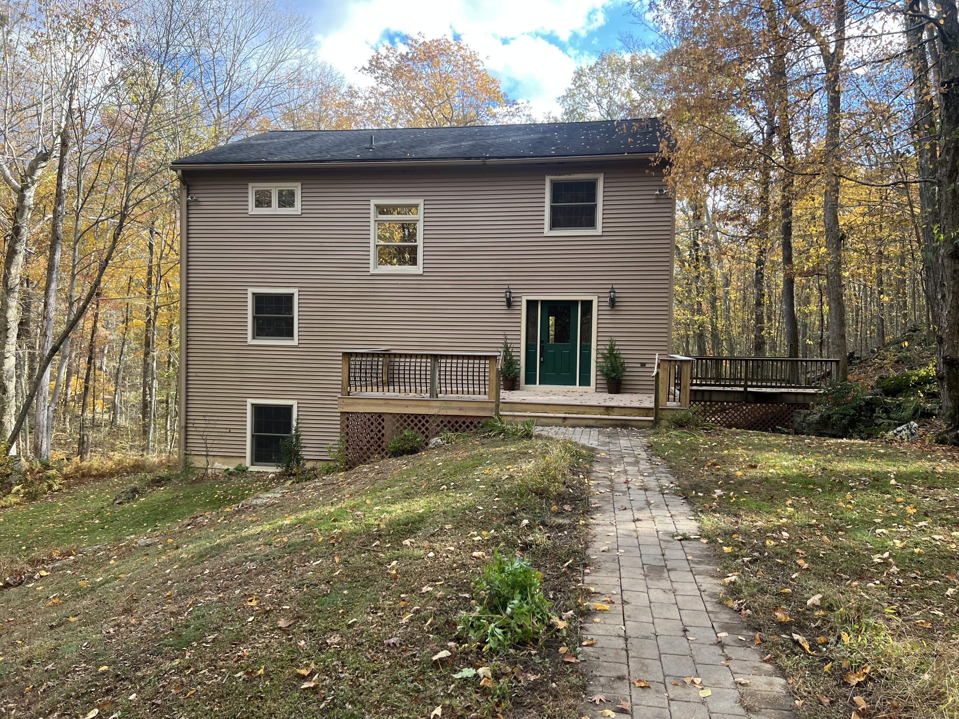 a view of backyard of house with wooden fence